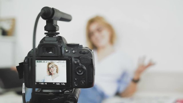 Female blogger is turning on the camera and strating recording video