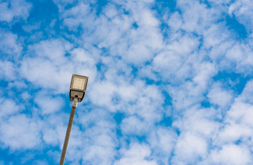 Led street light close up, blue sky with white clouds in the background, copy space.