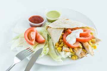 Burrito wrap with tomato, corn, lettuce, chicken, mayonnaise and sauces with white background