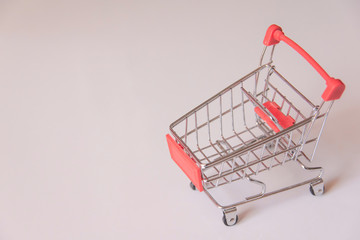 Red shopping supermarket cart on white background with copy space