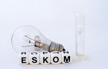 A fused electric light globe, a hourglass and the name eskom in black text on a white background...