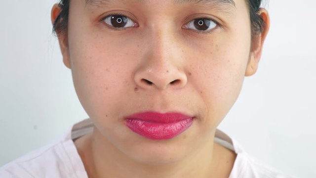 Shot of Asian young woman making face, do not care or unhappy sad face, over white background in studio.