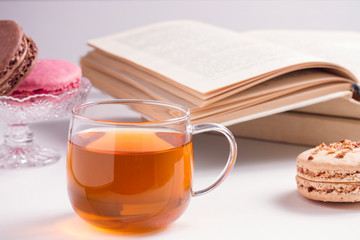 macaroons with tea on a white wooden background