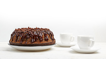 Homemade chocolate cake in form of a ring and two cups of coffee