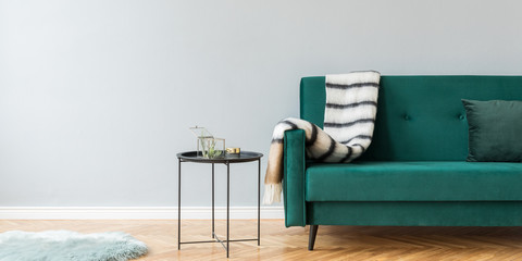 Minimalistic and luxury grey home interior with green velvet design sofa, black coffe table with...