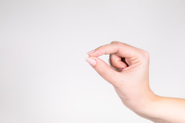 Closeup view of single female hand holding virtual card or invisible object with her fingers...
