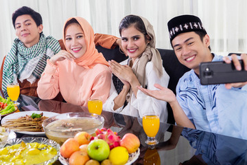 Happy Muslim people take photo before eating