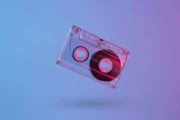 Minimalism retro style concept. 80s. Audio cassette in neon red blue light. Retro wave