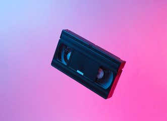 Minimalism retro style concept. 80s. Video cassette in neon red blue light. Retro wave
