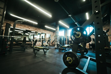 Gym equipment. Dark Gym with barbells on rack. Fitness workout center. Sport concept.