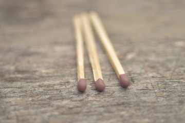 Three match sticks on wooden background 
