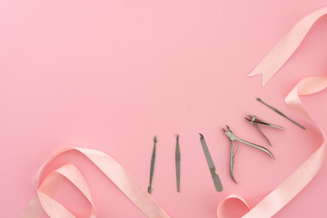 Tools of manicure set for nail care on a pink background with a bow. Beauty concept. Copyspace mockup