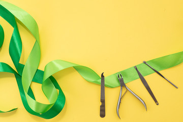 Tools of manicure set for nail care on a yellow background with a green bow. Beauty concept....