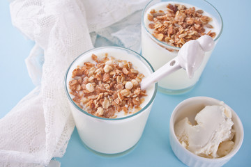 Yogurt in glass with muesli, cream cheese on a table with white napkin.