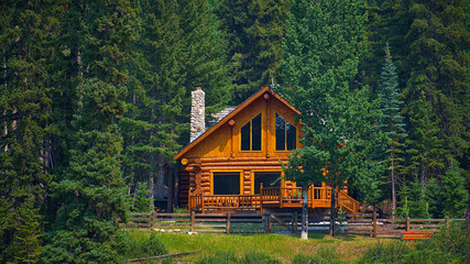 Wooden house commonly found near lakes and rivers. Rocky mountain ( Canadian Rockies ). Portrait, fine art. Near the city of Calgary. Jasper and Banff National Park, Alberta, Canada: August 2, 2018 - Powered by Adobe