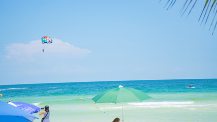 Tropical beach background with beautiful blue sea and parachute  , crystal clear sea and white sand with palms