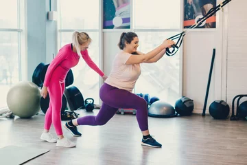 Foto op Aluminium Fitness instructor trains fat woman © MZaitsev