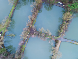 Aerial view of countryside, forest and farm field, lake with houses, Belgium, Bousval © Unwind