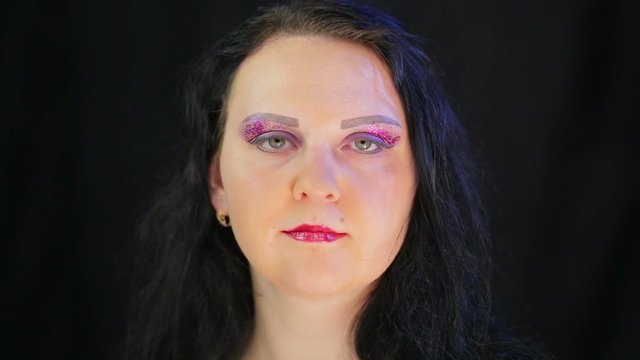 Brunette woman with ready bright eye and lip makeup. The average plan