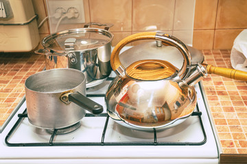 Saucepans, a frying pan and a kettle on the gas stove