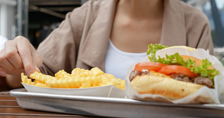 Obraz na płótnie Canvas Woman eat french fries and burger