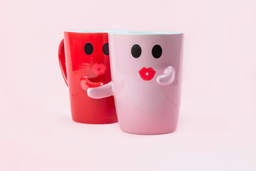 Friday's happy word. Two cups of coffee on a pink background with a smile face to the mug, hugging each other. The concept of love and relationships. Creative colorful greeting card