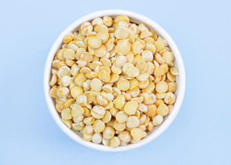 peas in a plate on top, on a blue background, copy space