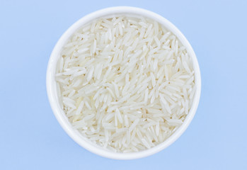 rice in a plate on top, on a blue background, copy space