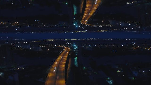 Moscow at night with urban architecture and river across the bridge, Russia, mirror horizon effect. Media. Aerial night view of a river bridge and city lights, night life concept, inception theme.