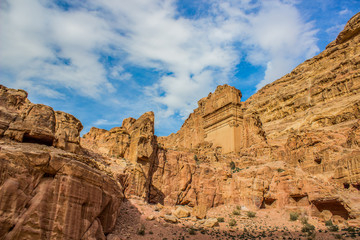 Fototapeta premium famous world heritage touristic site ancient Middle East Petra temple building carved in sand stone rocks in Wadi Musa region in Jordan country, picturesque bare mountains scenic landscape 