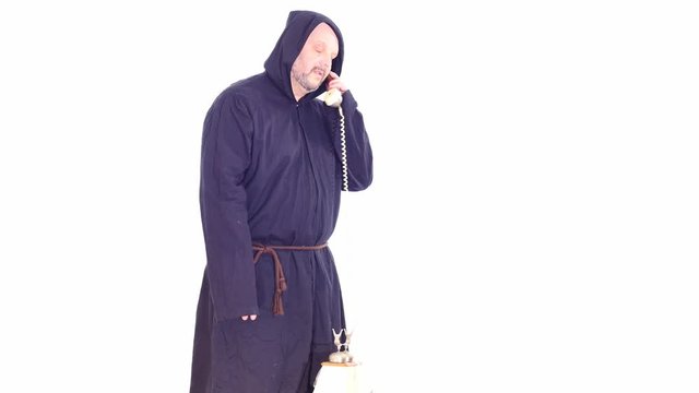 man in monk hoodie speaking by vintage phone white screen