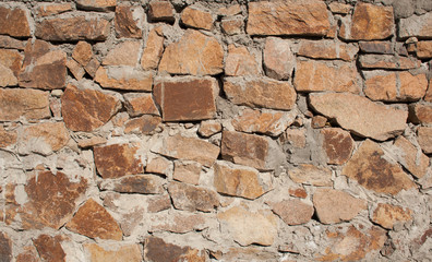 The texture of the wall with large stones. Small stones in between large stones
