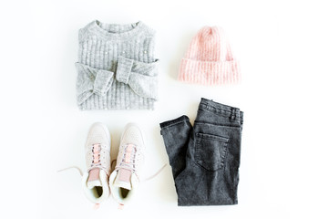 Women fashion clothes and accessories. Feminine youth collage on white background top view. Flat lay female style look with warm sweater, jeans, hat, sneakers, glasses. Top view.