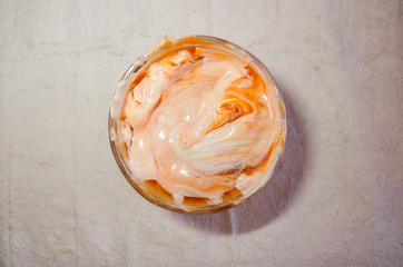 mixing mayonnaise with ketchup in glass bowl
