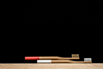 white and red colour Bamboo toothbrushes on a slate background. Place for text.
