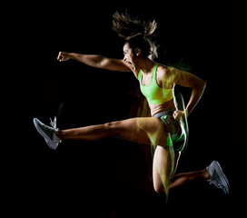 one mixed race woman exercising fitness exercises isolated on black background with lightpainting...