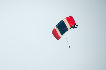 Parachutist on blue sky preparing for landing