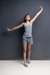 fitness woman. Young sporty Caucasian female model isolated on gray background in full body.