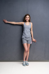 fitness woman. Young sporty Caucasian female model isolated on gray background in full body.