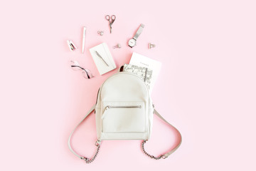 Women beige backpack and accessories on pink background top view. Flat lay female style look. Top view.