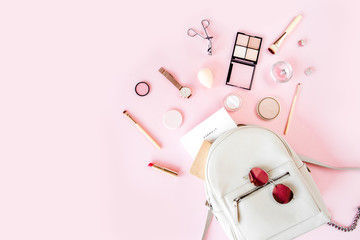 Women beige backpack and accessories on pink background top view. Flat lay female style look. Top view.