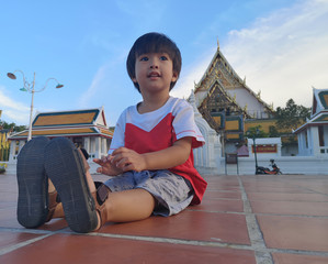 The boy sitting down relaxable in public place.