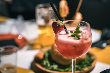 Strawberry cocktail served in a pub, glass tumbler and straw