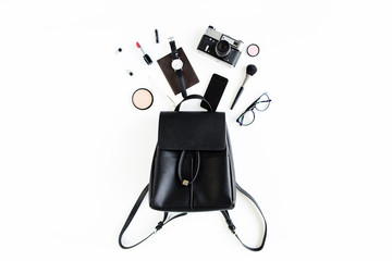 Women black backpack and accessories on white background top view. Flat lay female style look. Top view.