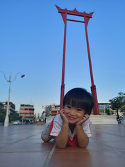 The boy laying down relaxable in public place.