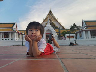 The boy laying down relaxable in public place.