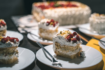 Strawberry and cream birthday cake served by the waiter in ceramic dishes