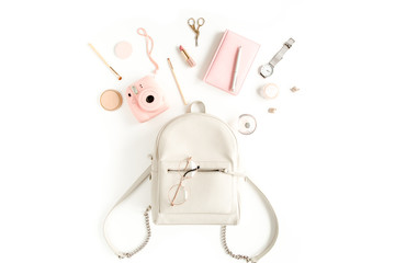Women's beige backpack with fashion accessories on white background top view. Flat lay female style look. Top view.