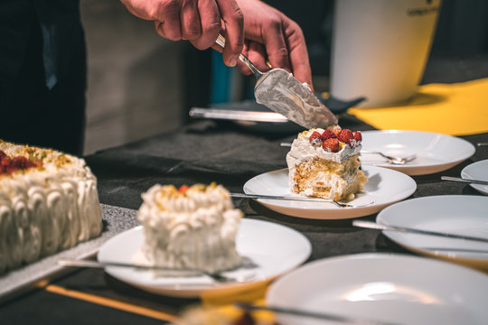 Strawberry and cream birthday cake served by the waiter in ceramic dishes