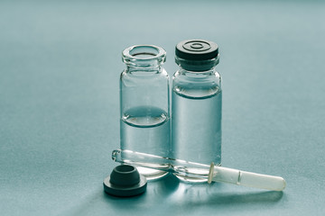 Medicine bottles and pipette on blue background. Medicines for individual preparation. Drip medication. Dropper glass. Bottle Mock-Up